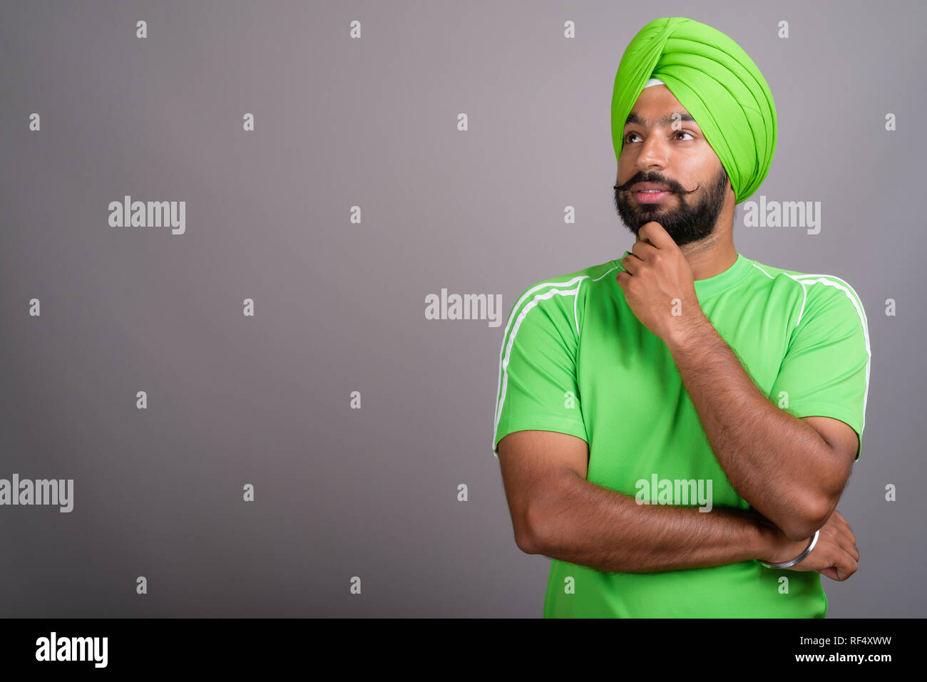 Joven apuesto Sikh indio hombre vestido con turbante y camiseta verde  Fotografía de stock - Alamy