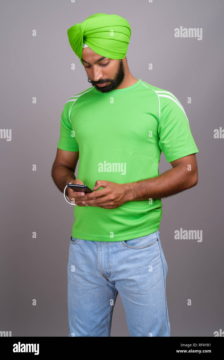 Joven apuesto Sikh indio hombre vestido con turbante y camiseta verde  Fotografía de stock - Alamy