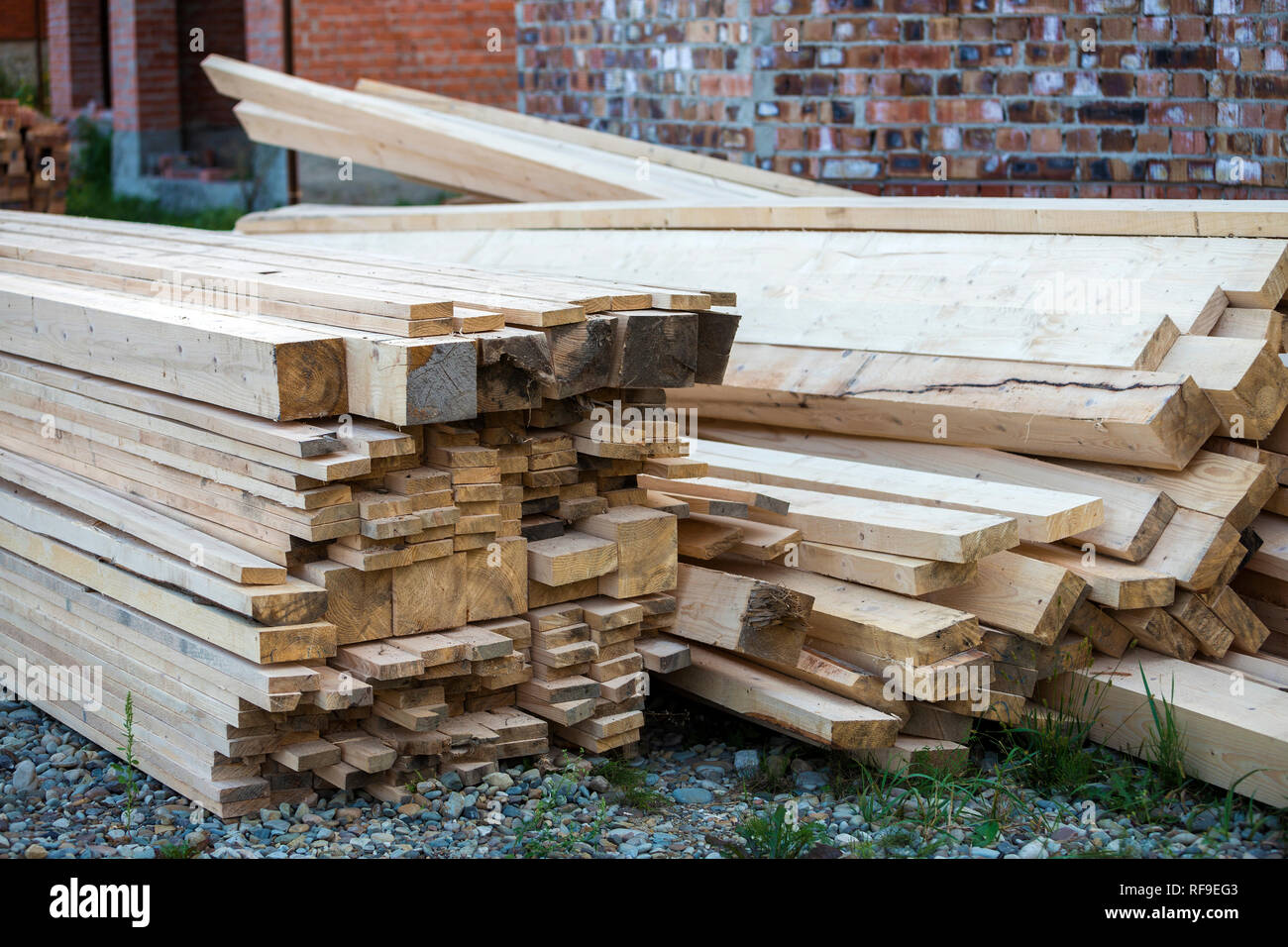 Pila de marrón natural desigual tableros de madera áspera en el sitio de  construcción. La explotación industrial de madera para carpintería,  construcción, reparación y muebles, madera matéria Fotografía de stock -  Alamy