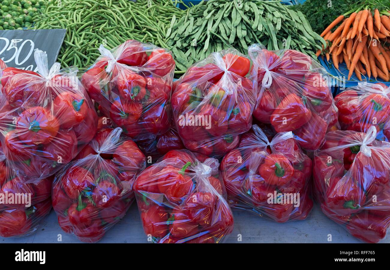 Pimiento rojo (Capsicum) en bolsas de plástico en un puesto de frutas, Países Bajos Foto de stock