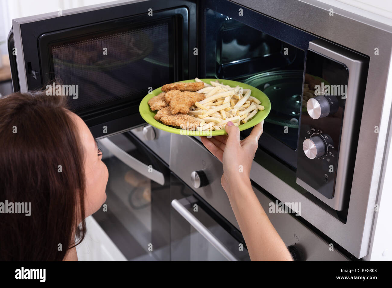 Close-up de una joven mujer calentar alimentos fritos en horno microondas  Fotografía de stock - Alamy