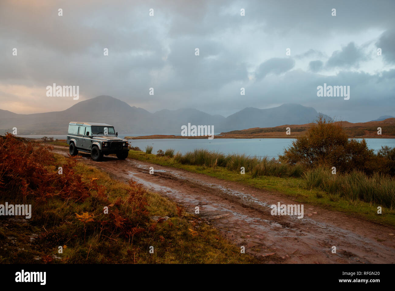 Un Land Rover por una pista de tierra en la campiña de Escocia al atardecer Foto de stock