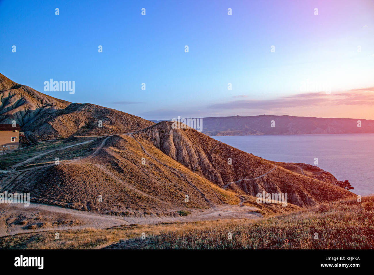 Impresionantes vistas al mar desde la cima de la colina con la puesta de sol Foto de stock