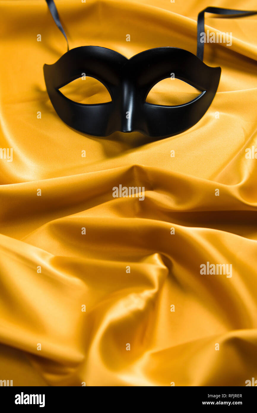 Sexy antifaz negro sobre un fondo de seda amarillo Fotografía de stock -  Alamy