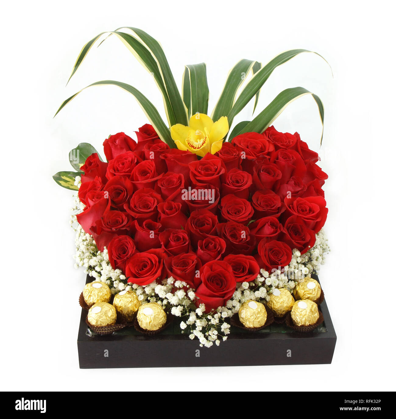 Regalo Floral arreglo con rosas rojas con bombones dentro de un bote de  madera sobre fondo blanco Fotografía de stock - Alamy