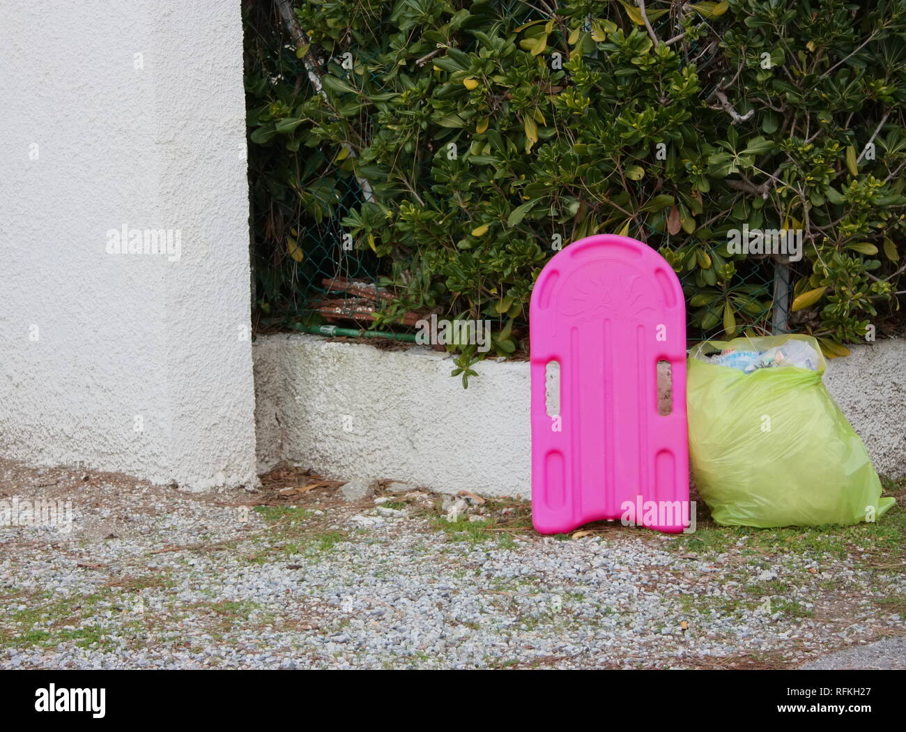Boca para aprender a nadar en una niña de color fucsia. final de la temporada de verano. inútil objeto a ser destrozados, abandonada al lado de la carretera, junto con Foto de stock