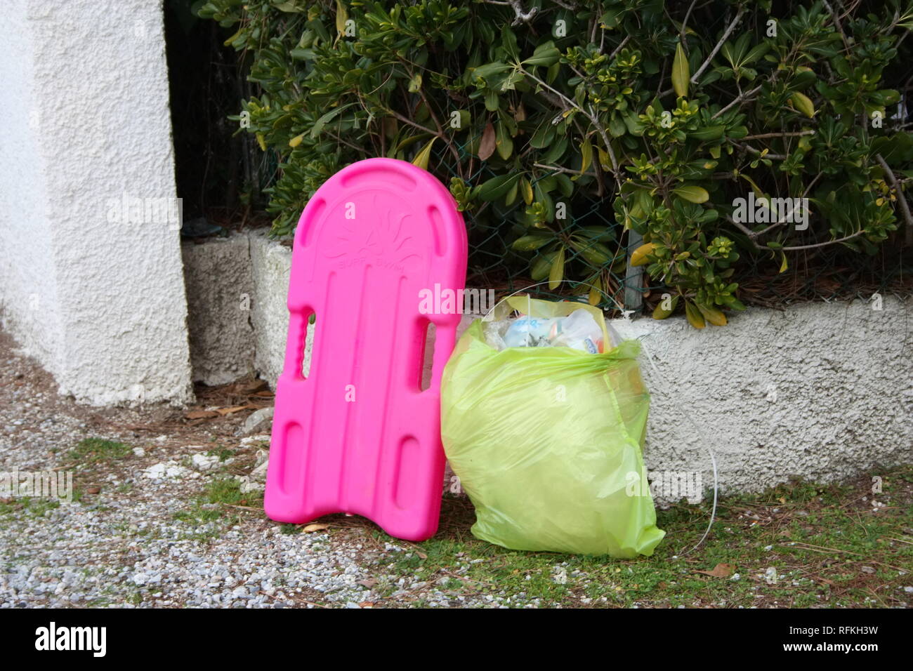 Boca para aprender a nadar en una niña de color fucsia. final de la temporada de verano. inútil objeto a ser destrozados, abandonada al lado de la carretera, junto con Foto de stock