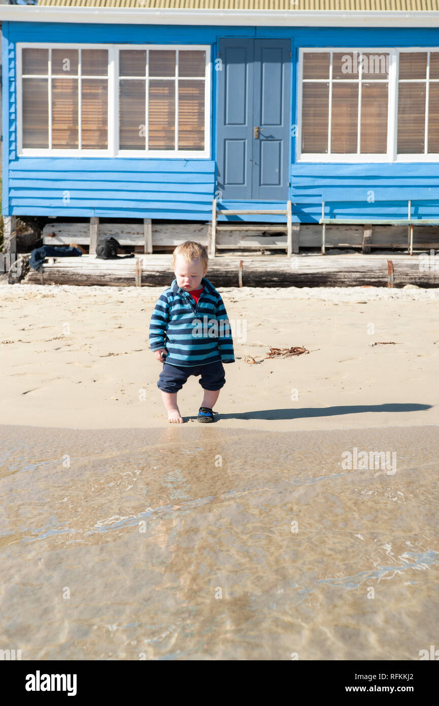 Niño jugando en la playa, Tasmania, Australia Foto de stock