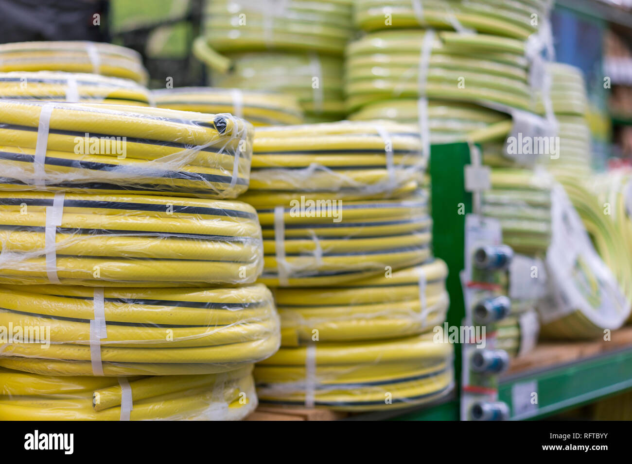Pilas de rollos de PVC amarillo tubo de plástico sobre el mostrador de la  tienda. Venta de mangueras en el jardín de diversos fabricantes, sobre  estantes en la tienda. Manguera para Fotografía