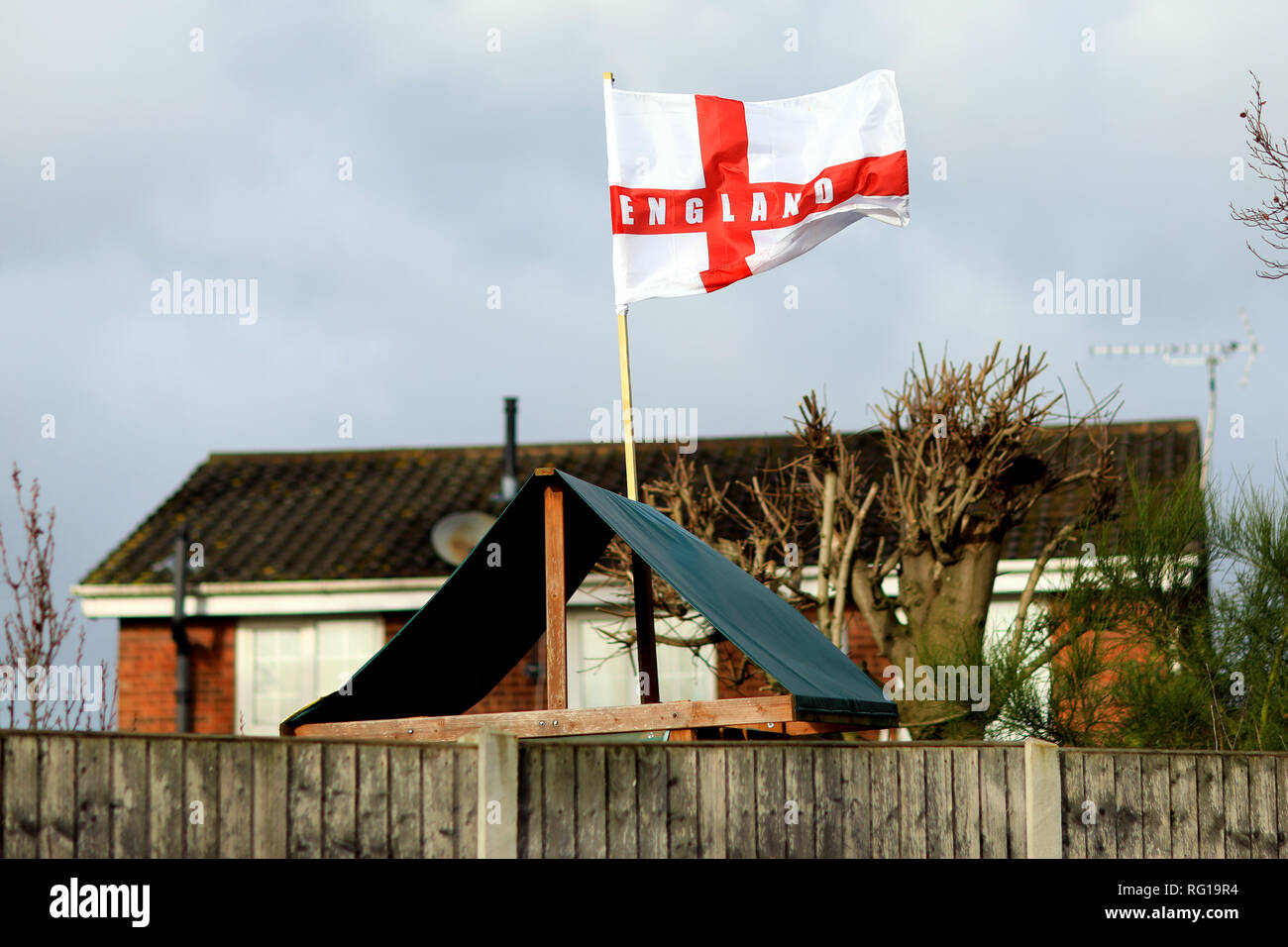 Un Inglés bandera ondea en el viento en el jardín de una casa en Inglaterra Foto de stock