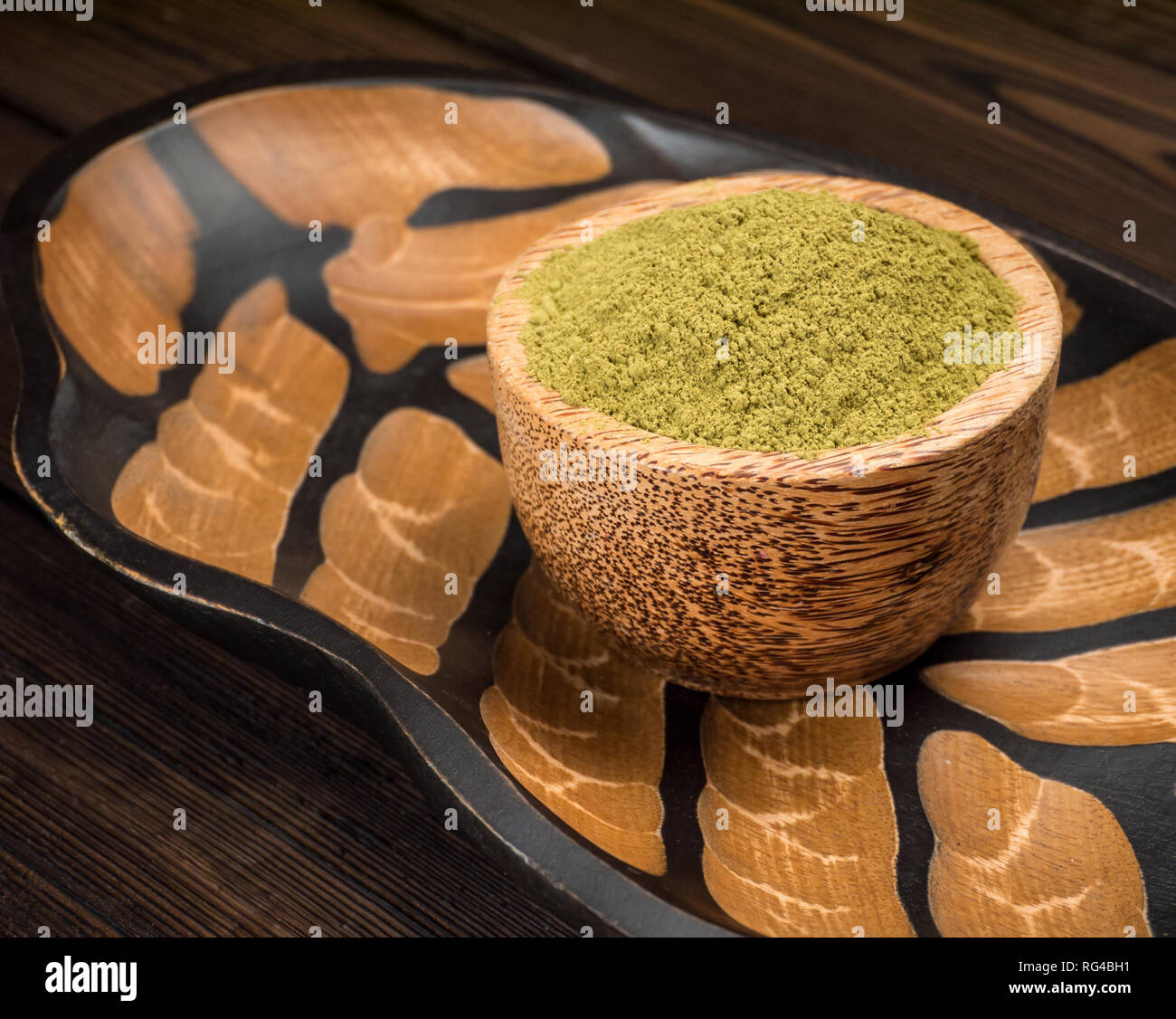 La henna en polvo colorante de cabello en el tazón de coco en la textura de fondo de madera Foto de stock