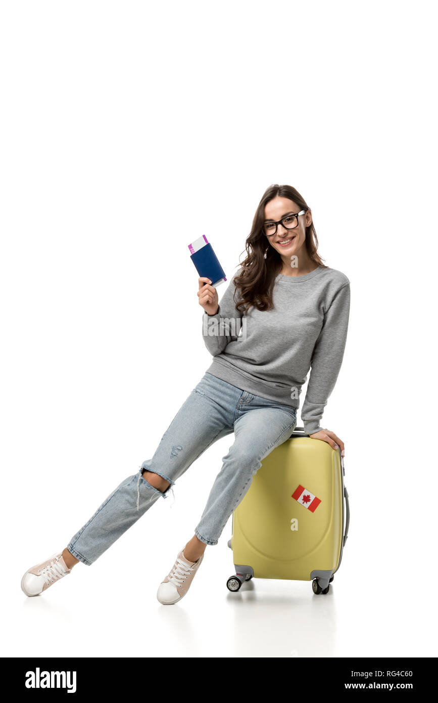 Feliz mujer sentada sobre la maleta con pasaportes y billetes de avión  aislado en blanco, el concepto de viaje Fotografía de stock - Alamy