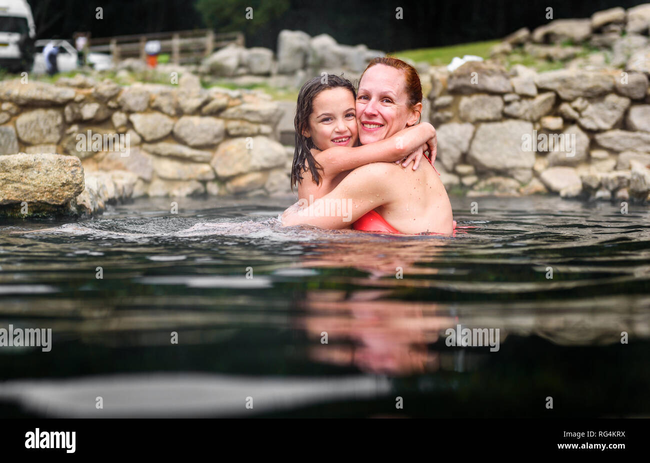 Madre e hija relajante en el balneario romano de aguas termales naturales. Retiro familiar en piscinas y baños con agua caliente, fumar agua termal caliente y SPR Foto de stock