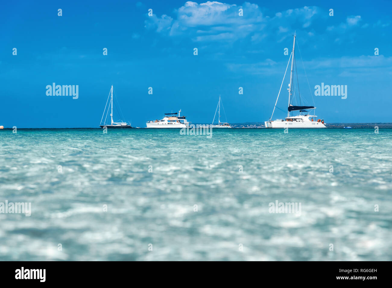 Barcos y yates en el mar transparente en el soleado día luminoso en verano en Mallorca, España. Vista desde el agua. Colorido paisaje con Bay, el agua azul, s Foto de stock