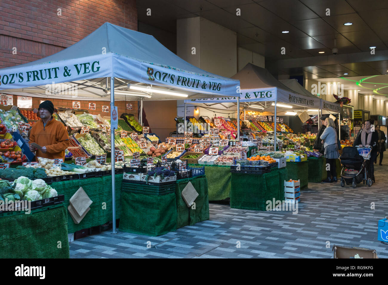 Los puestos de mercado de frutas y verduras en el mercado del centro de la ciudad andando en Woking, Surrey, Reino Unido, con la gente de compras. La vida cotidiana. Foto de stock