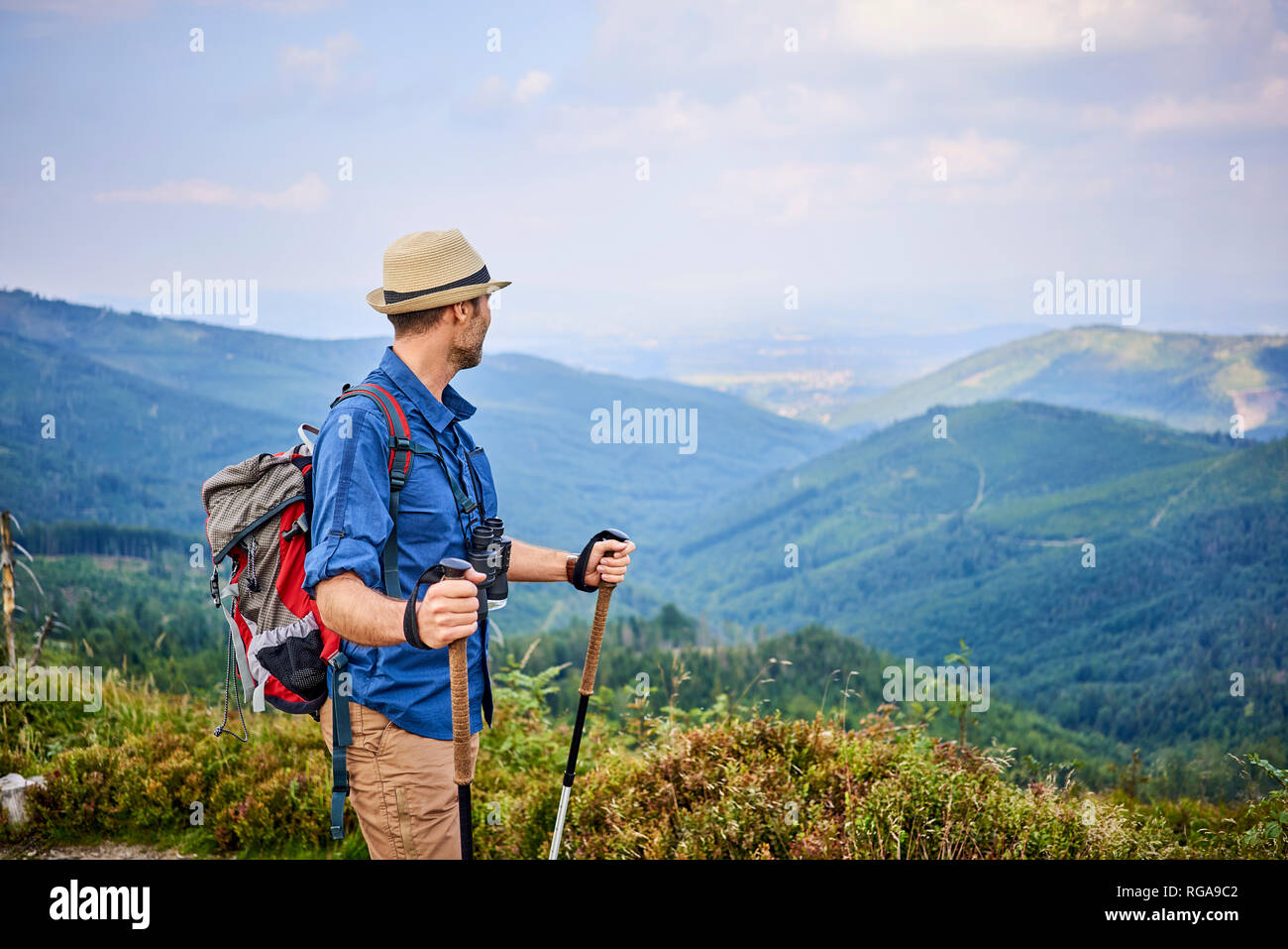 Hombre admirando la vista de la montaña durante la excursión Foto de stock