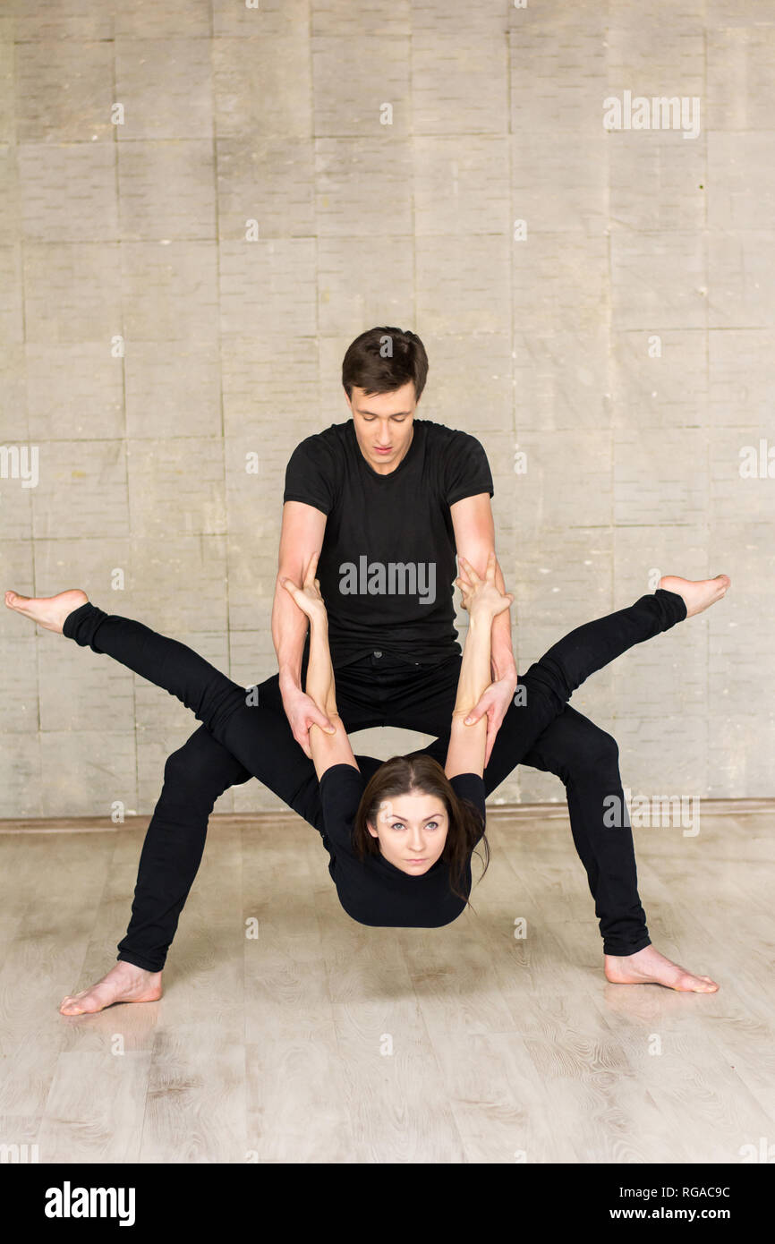 Pareja de bailarines en pose dinámica. El hombre y la mujer joven en trajes  negros realizan la danza moderna. Art Dance Studio Fotografía de stock -  Alamy