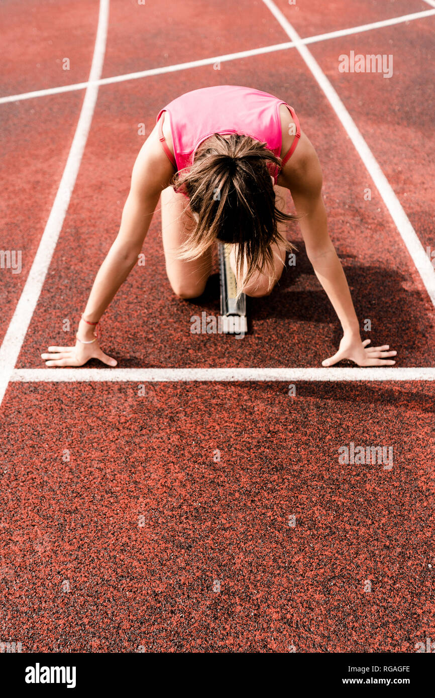 Teenage runner en posición inicial en pista Foto de stock