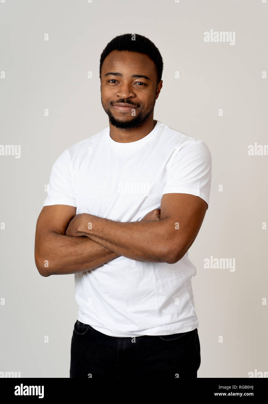 Retrato de atractivo, seguro joven afroamericano busca neutral relajada y exitosa en las expresiones faciales, las emociones humanas, éxito y Foto de stock