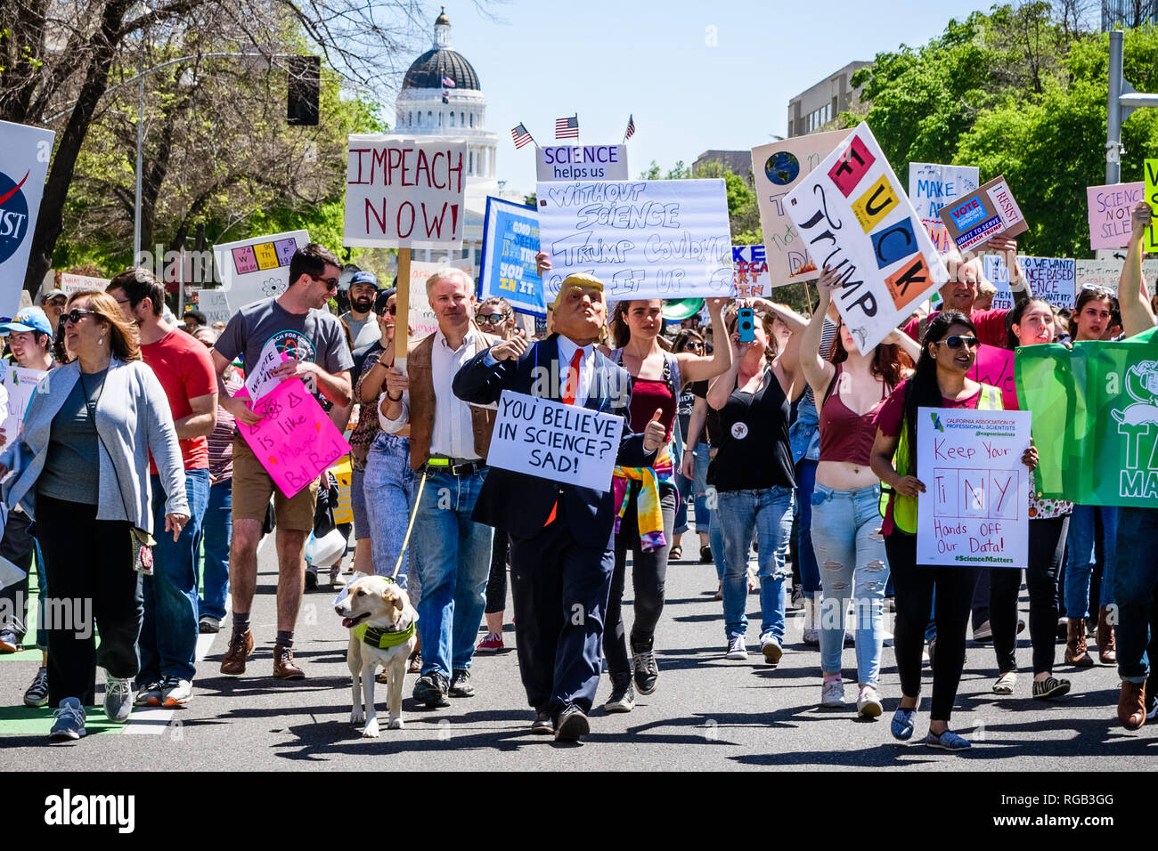 Abril 14, 2018 Sacramento / CA / EE.UU. - Los participantes a la marcha de la ciencia y el impuesto sobre la marcha Capitol Mall; una persona suplantando a Trump Foto de stock