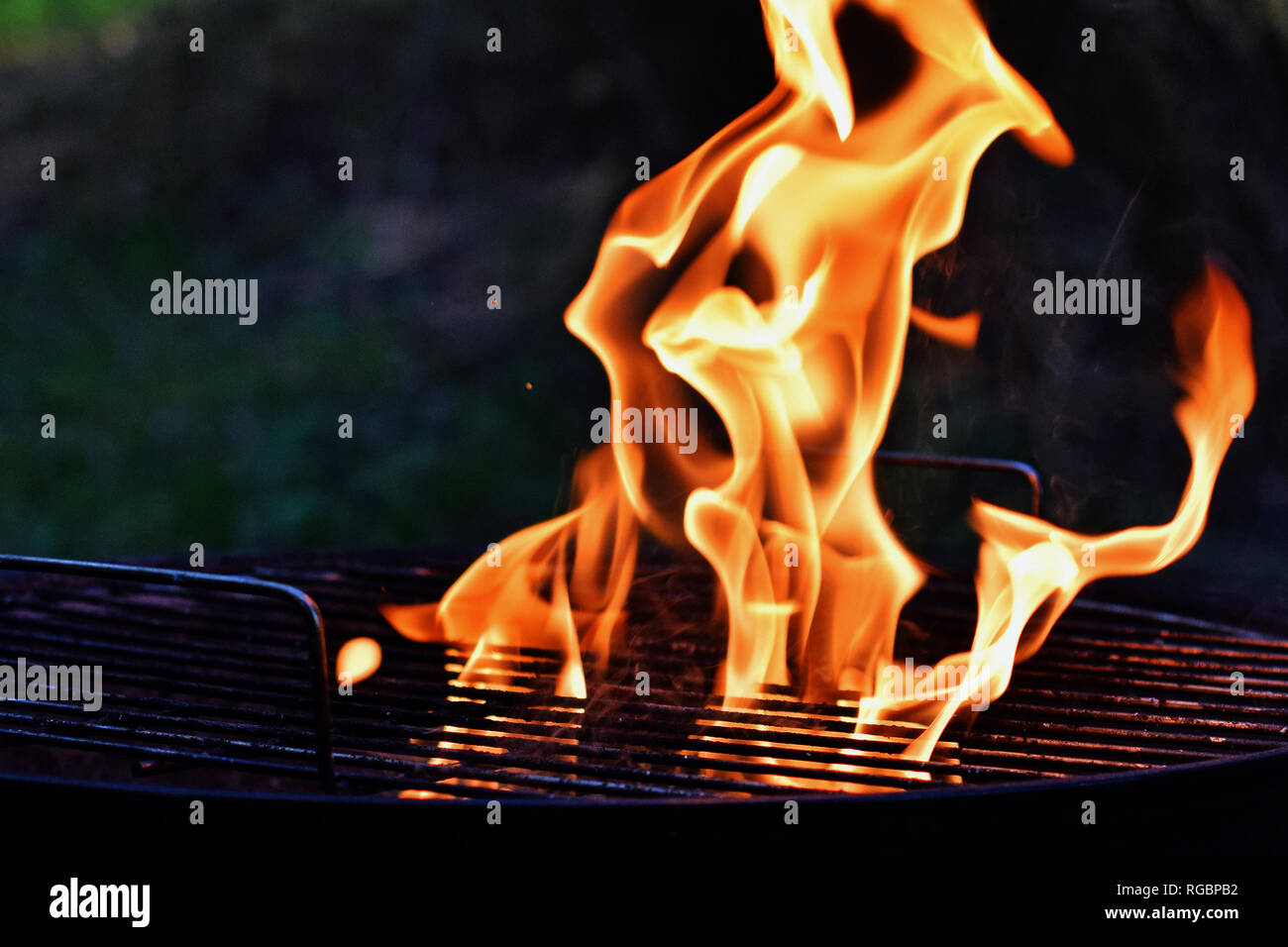 Belleza de las llamas en la parrilla de carbón. Cerca del fuego con espacio de copia. Foto de stock