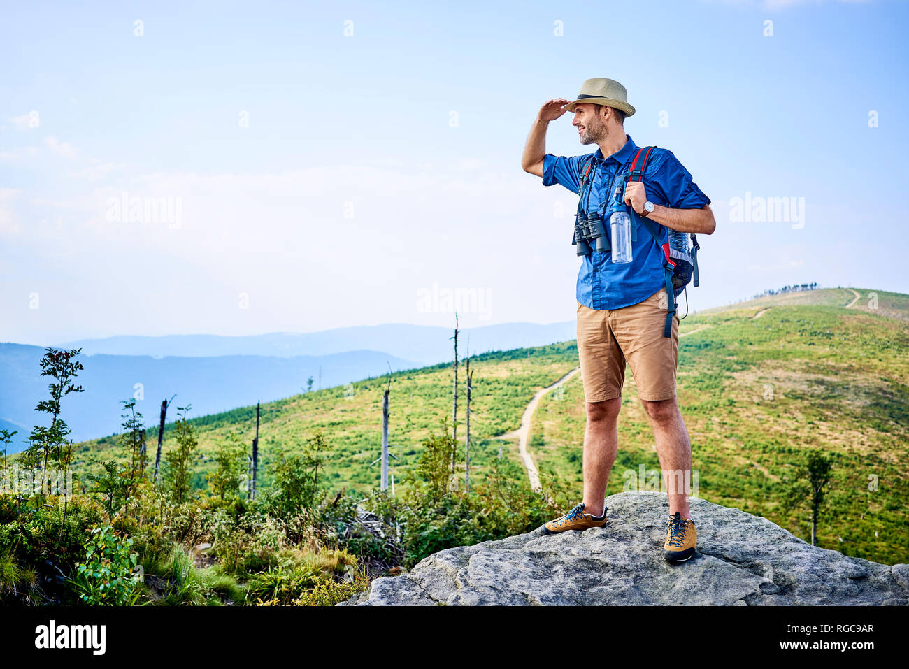 Hombre admirando la vista de la montaña durante la excursión Foto de stock