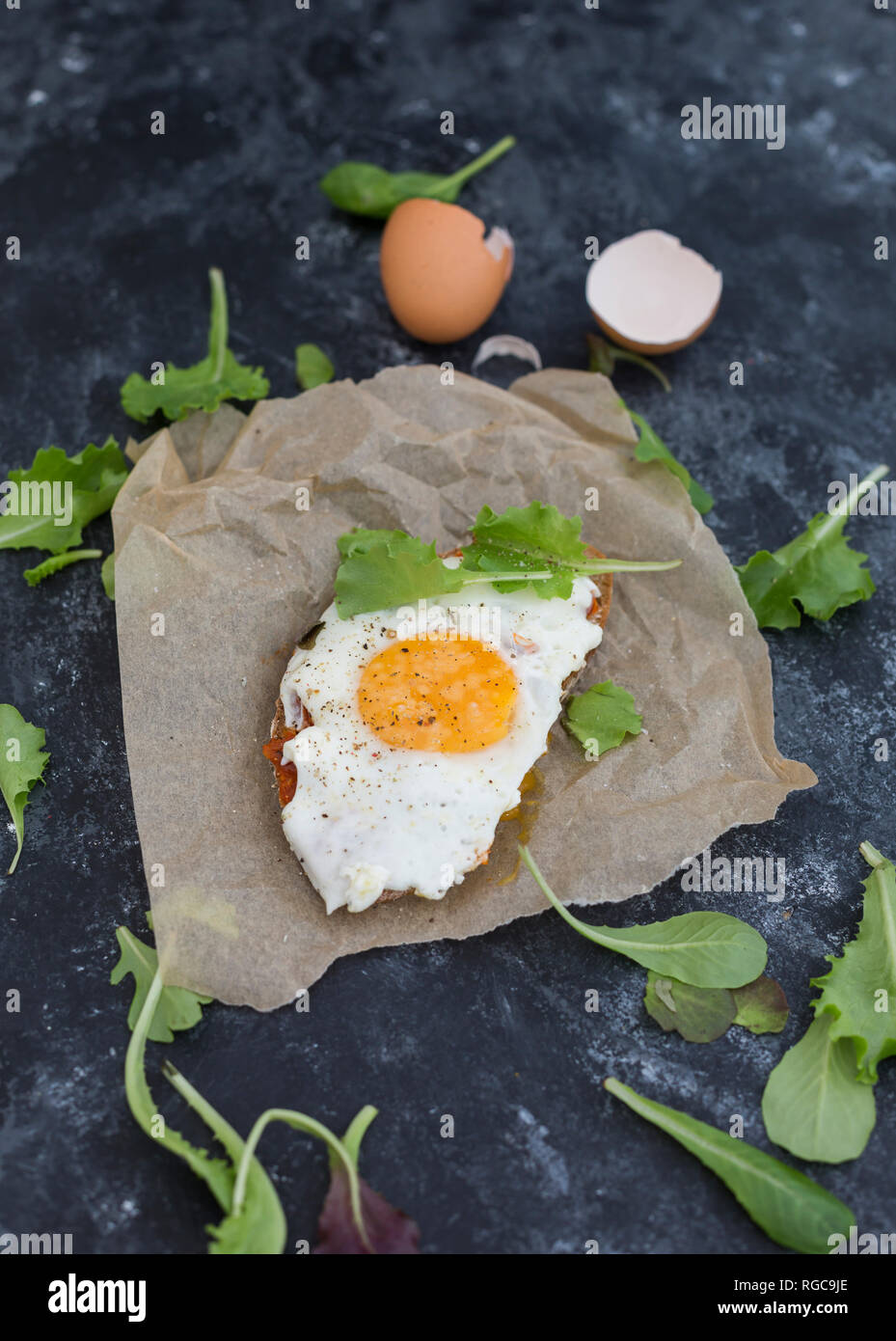 Huevo frito sobre la rebanada de pan untado con crema de pimentón Foto de stock