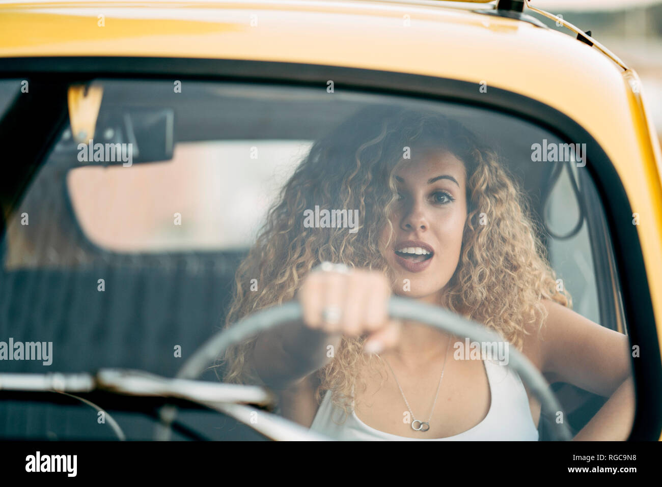 Retrato de mujer rubia sorprendió conduciendo coches clásicos Foto de stock