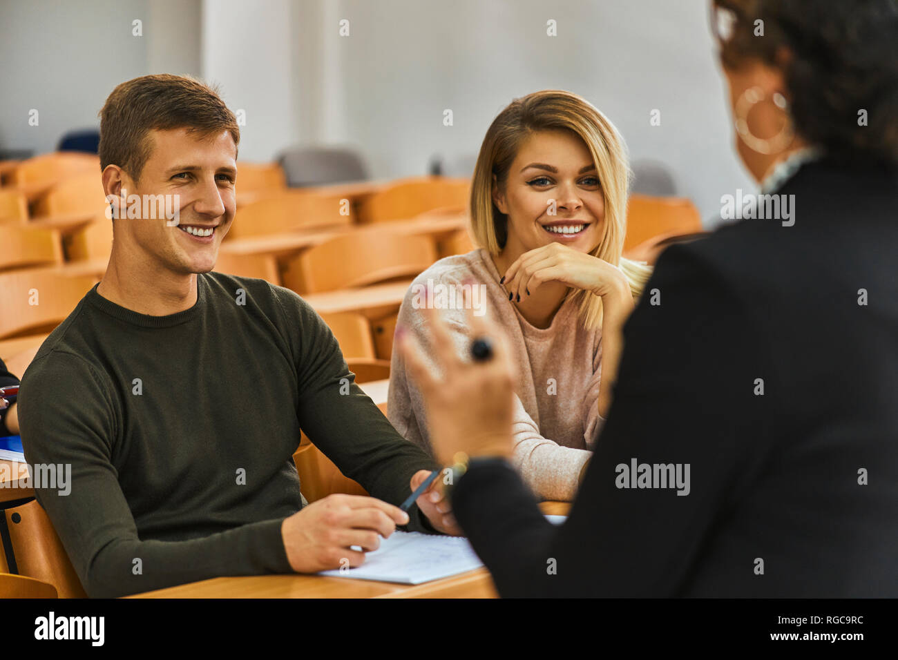 Los estudiantes sonriente y conferencista en el auditorium de la universidad Foto de stock