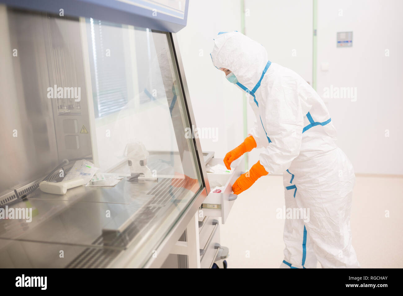 Técnico de laboratorio usando cleanroom globalmente en laboratorio para la producción de drogas Foto de stock