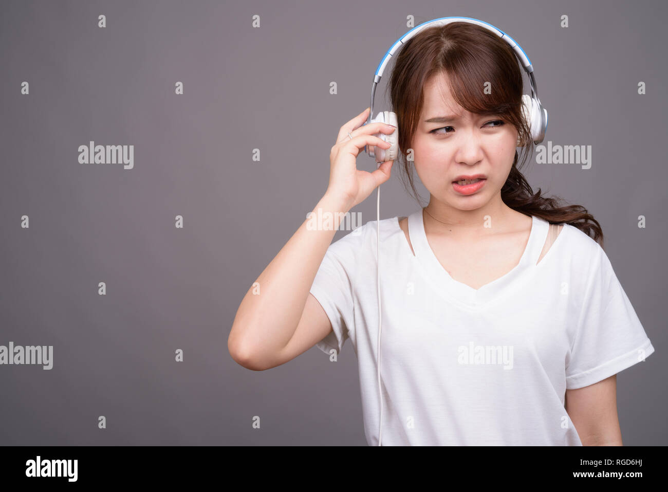 Hermosa joven mujer asiática usando audífonos para música Foto de stock