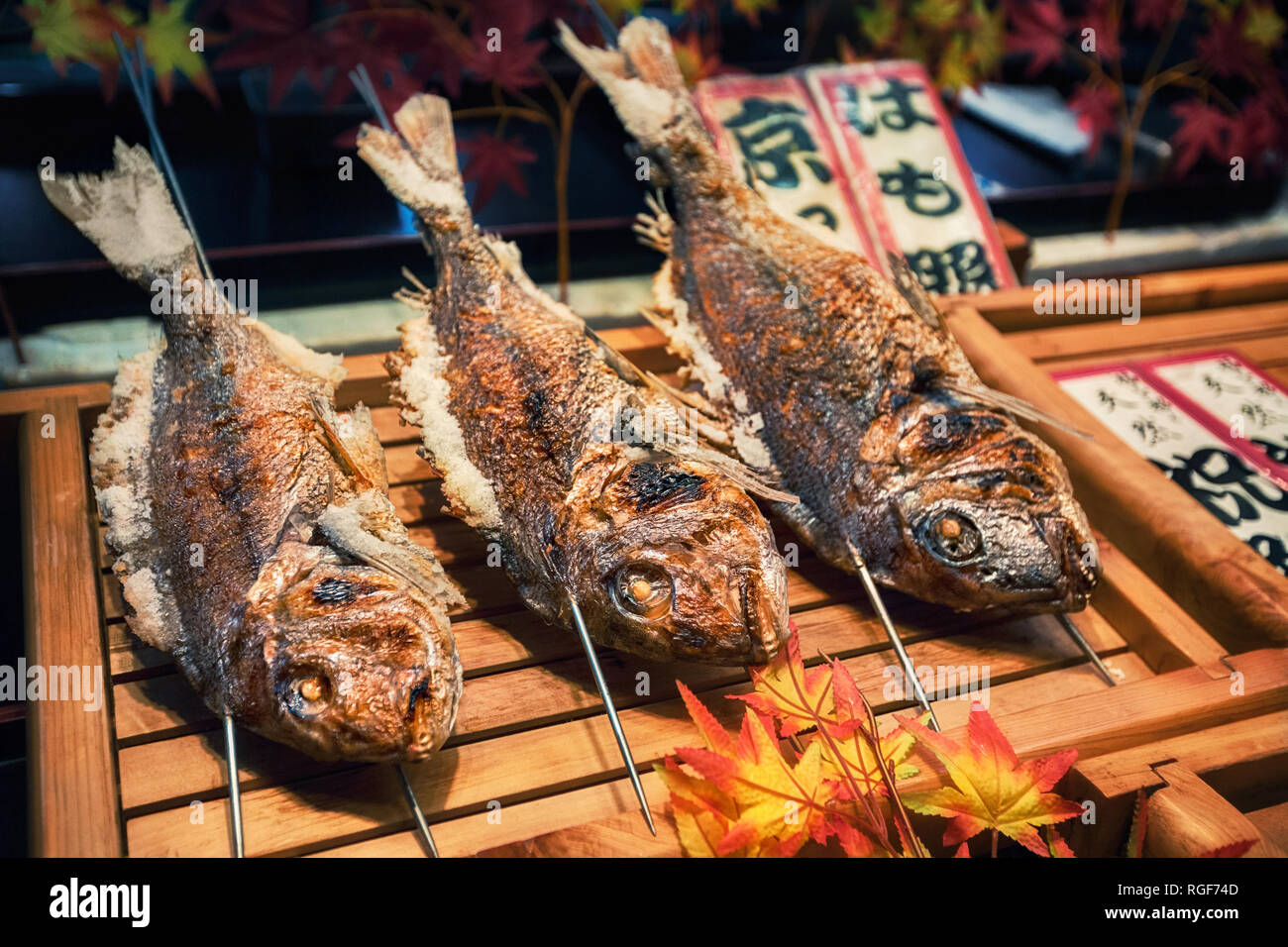 Parrillada de pescados en palos como la comida en la calle al mercado de Nishiki, Kyoto, Japón Foto de stock