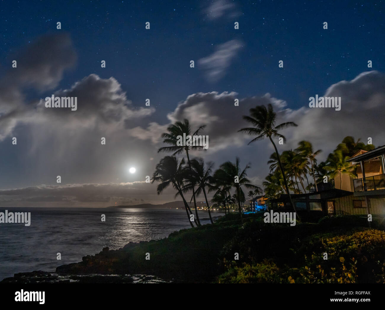 Moonlit costa del área de vacaciones con árboles de coco, las nubes y el océano. , Koloa Poipu, Kauai, Hawai Foto de stock