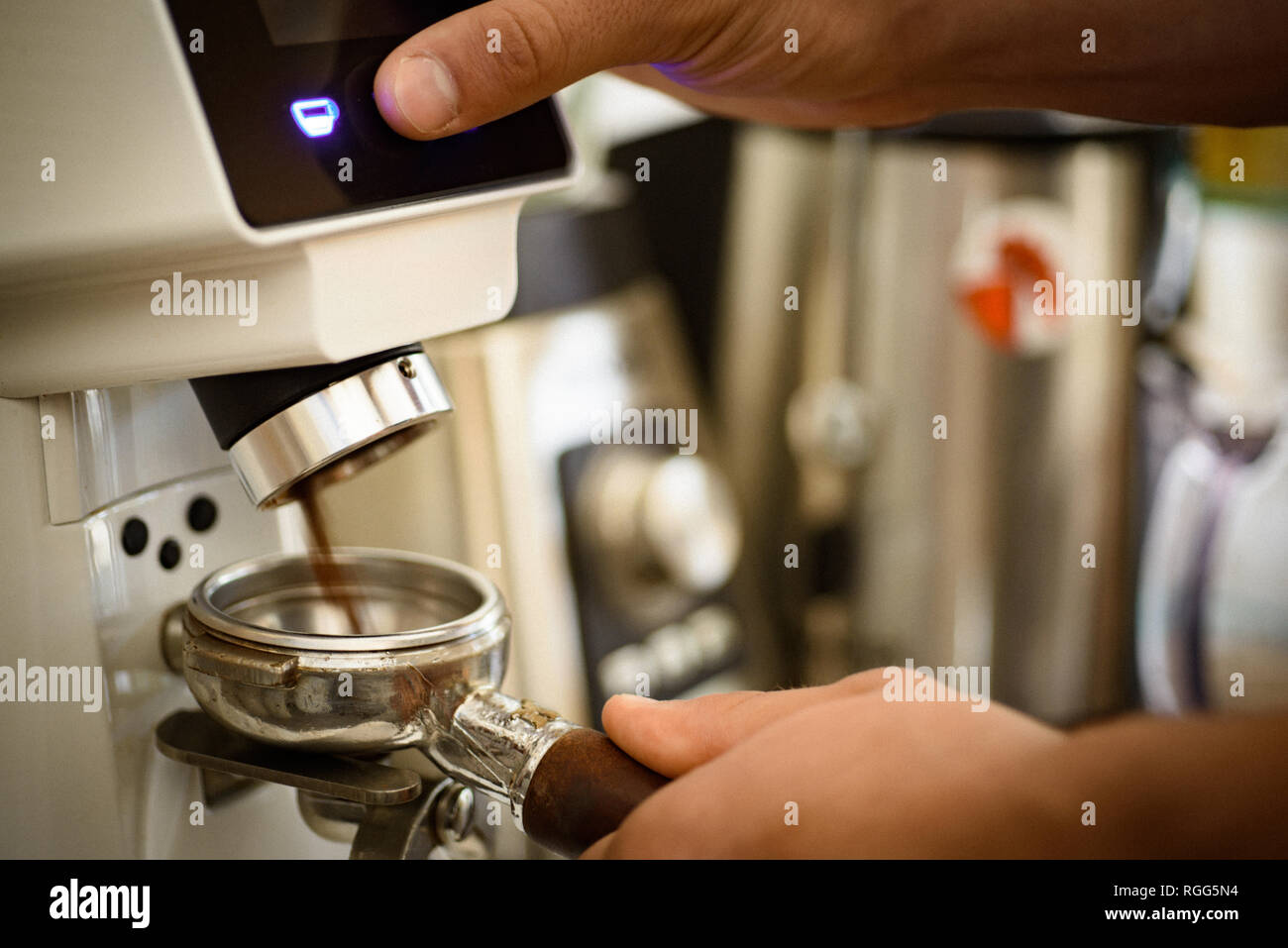 Basta con pulsar el botón. Café recién molido en portafilter. Barista moler  granos de café con máquina de café. Molinillo de café tostado moler granos  en Fotografía de stock - Alamy