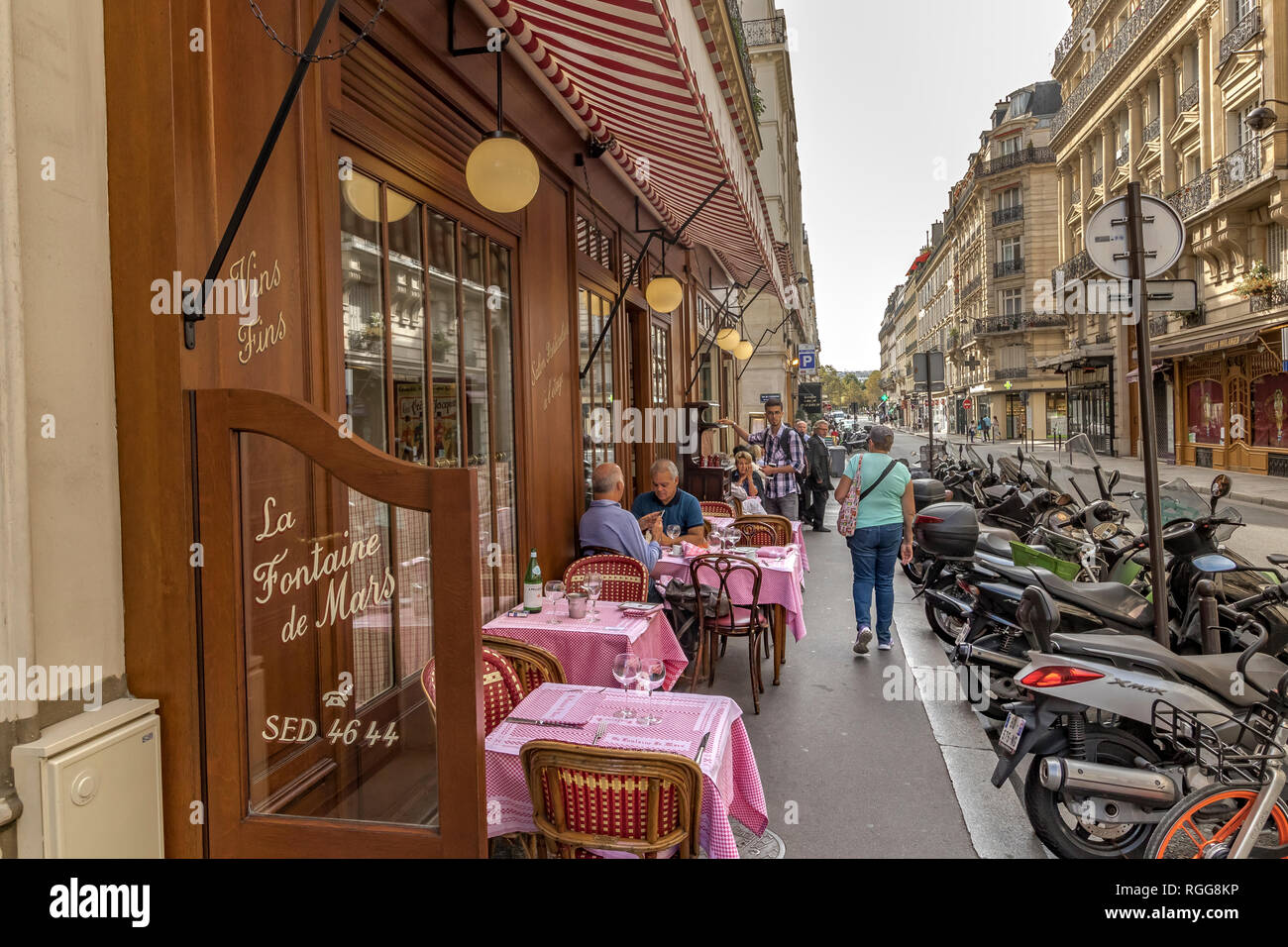 Gente sentada en una mesa comiendo en La Fontaine de Mars, un restaurante francés en Rue Saint-Dominique, París, Francia Foto de stock