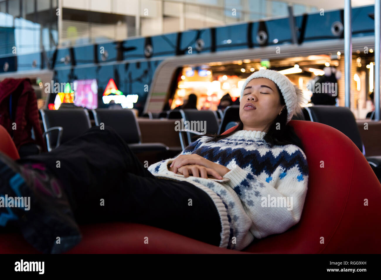 Chica tomando una siesta mientras esperan en la sala de espera de aeropuerto Foto de stock