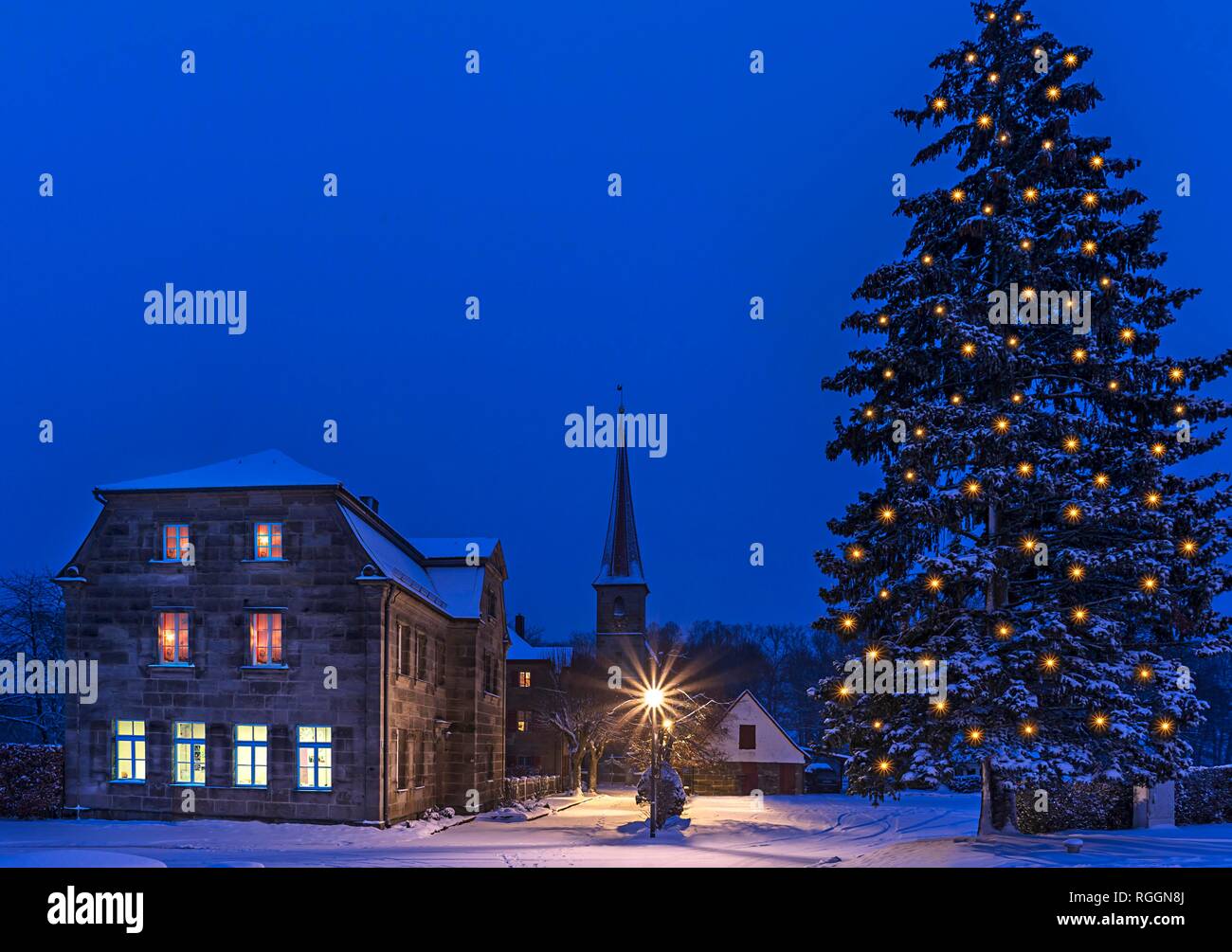 Salón parroquial, casa rectoral y St. Egidienkirche y árbol de Navidad con luces, Beerbach, Middle Franconia, Baviera, Alemania Foto de stock