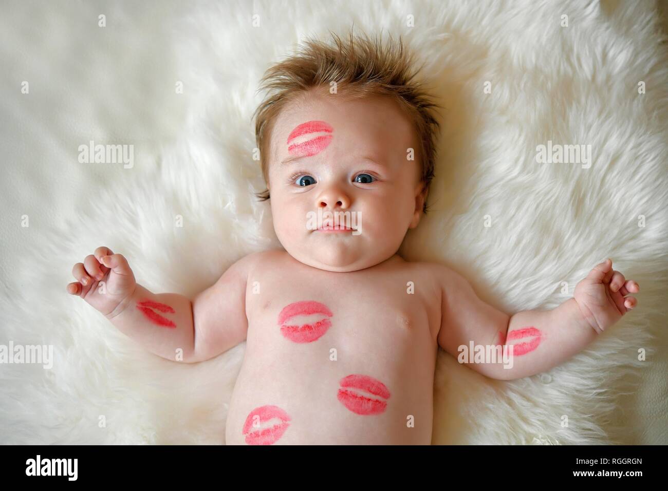 Bebé de tres meses, con besos roja desembocadura se encuentra en el pelaje, retrato, Baden-Württemberg, Alemania Foto de stock