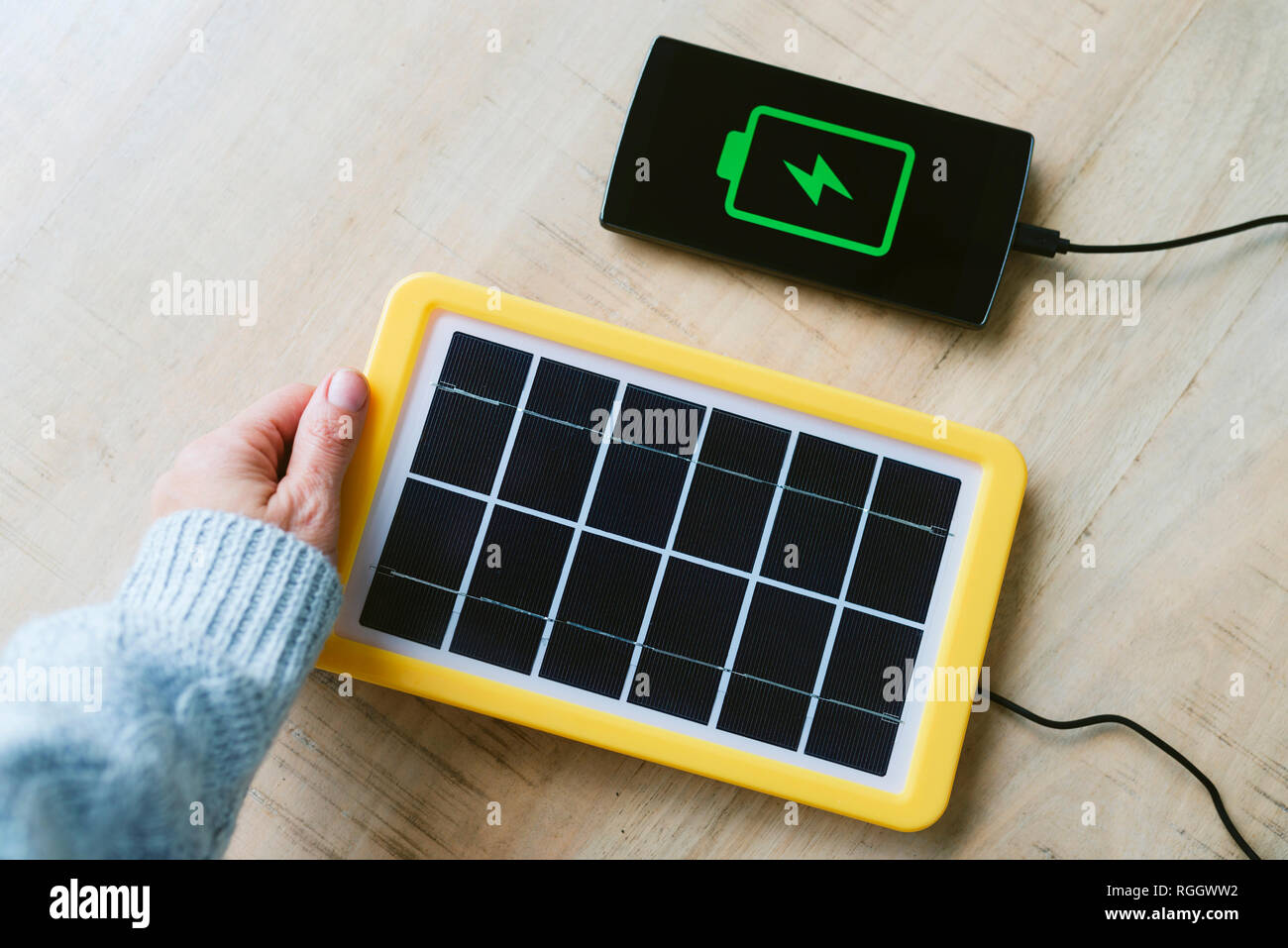 La tecnología de la energía renovable, el panel solar carga la batería del teléfono móvil. Foto de stock