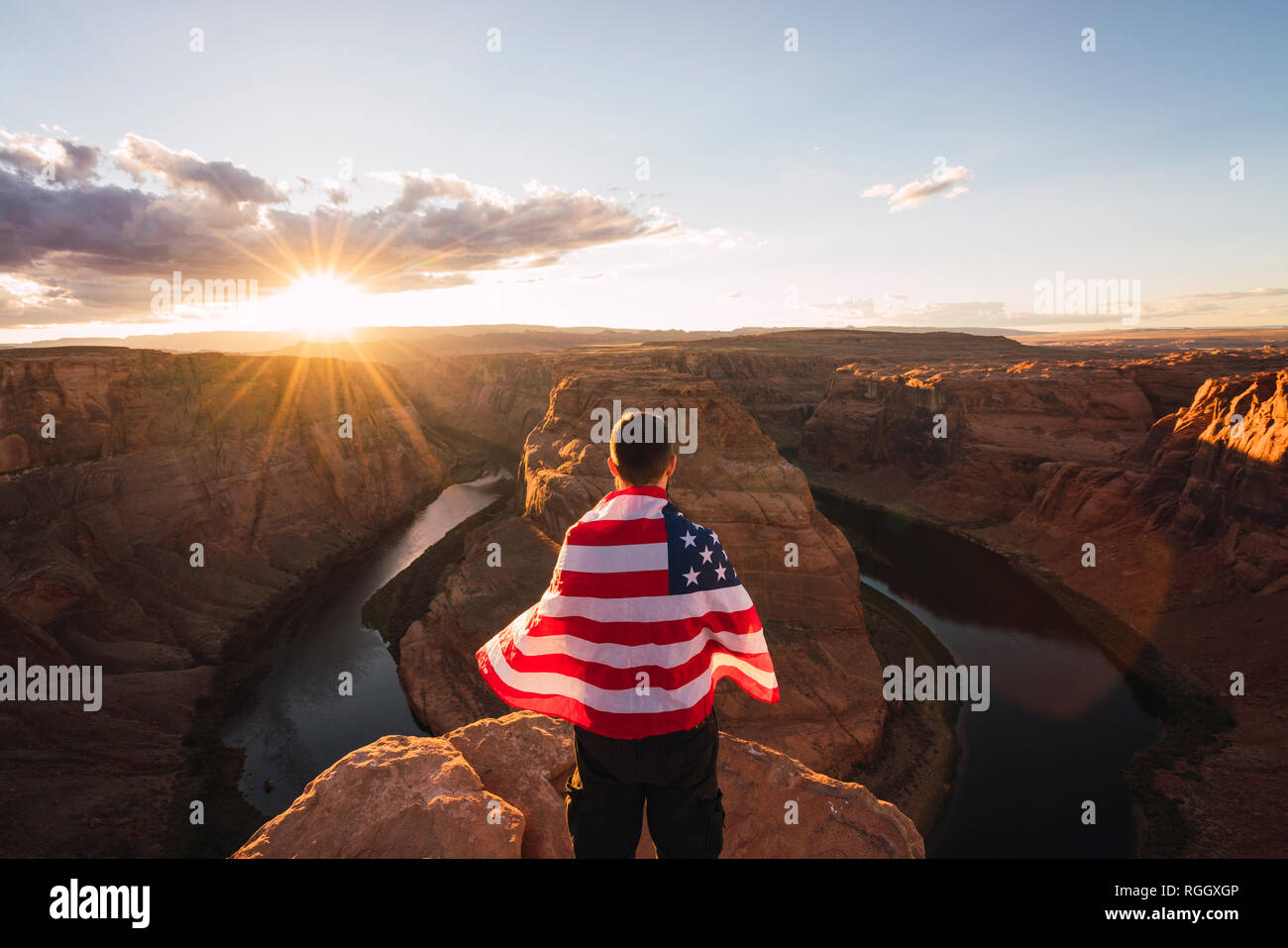 Ee.Uu., Arizona, Colorado River, Horseshoe Bend, joven en Viewpoint con bandera americana Foto de stock