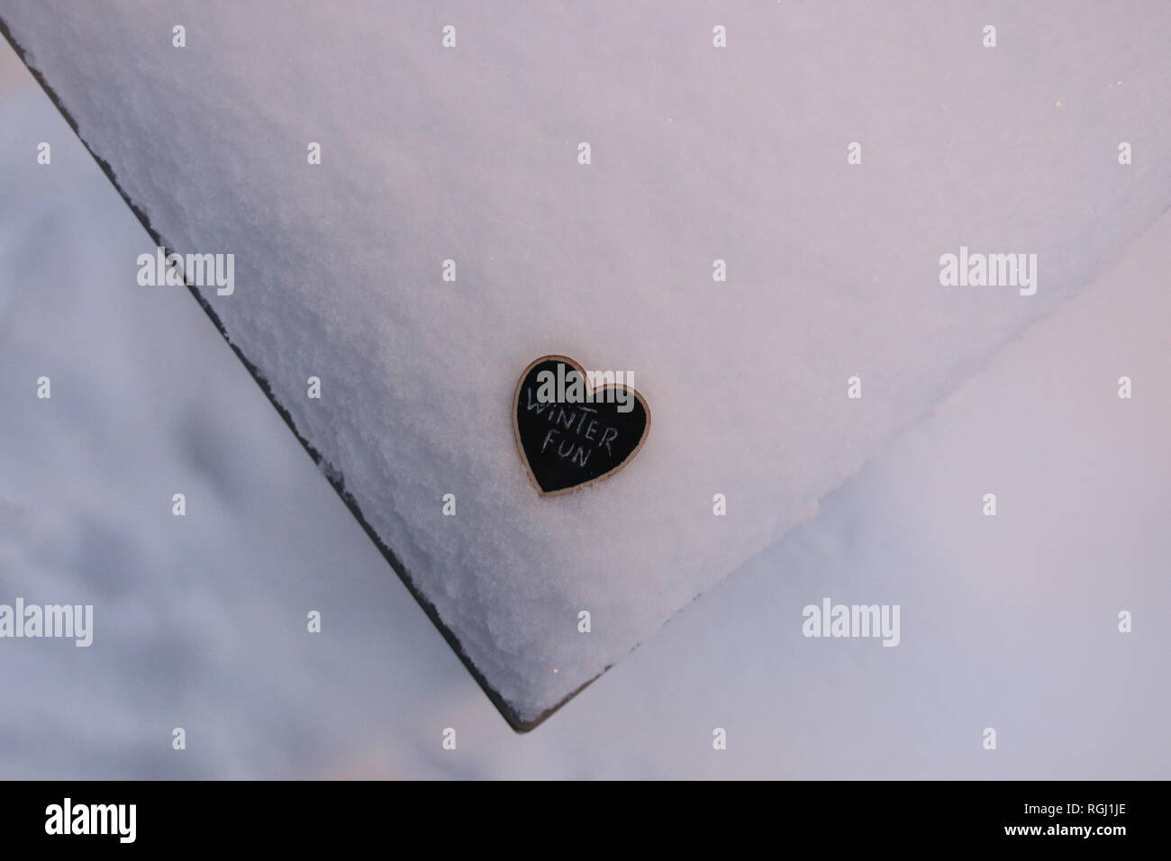 Diversión de invierno, placa en forma de corazón con la inscripción en la nieve Foto de stock