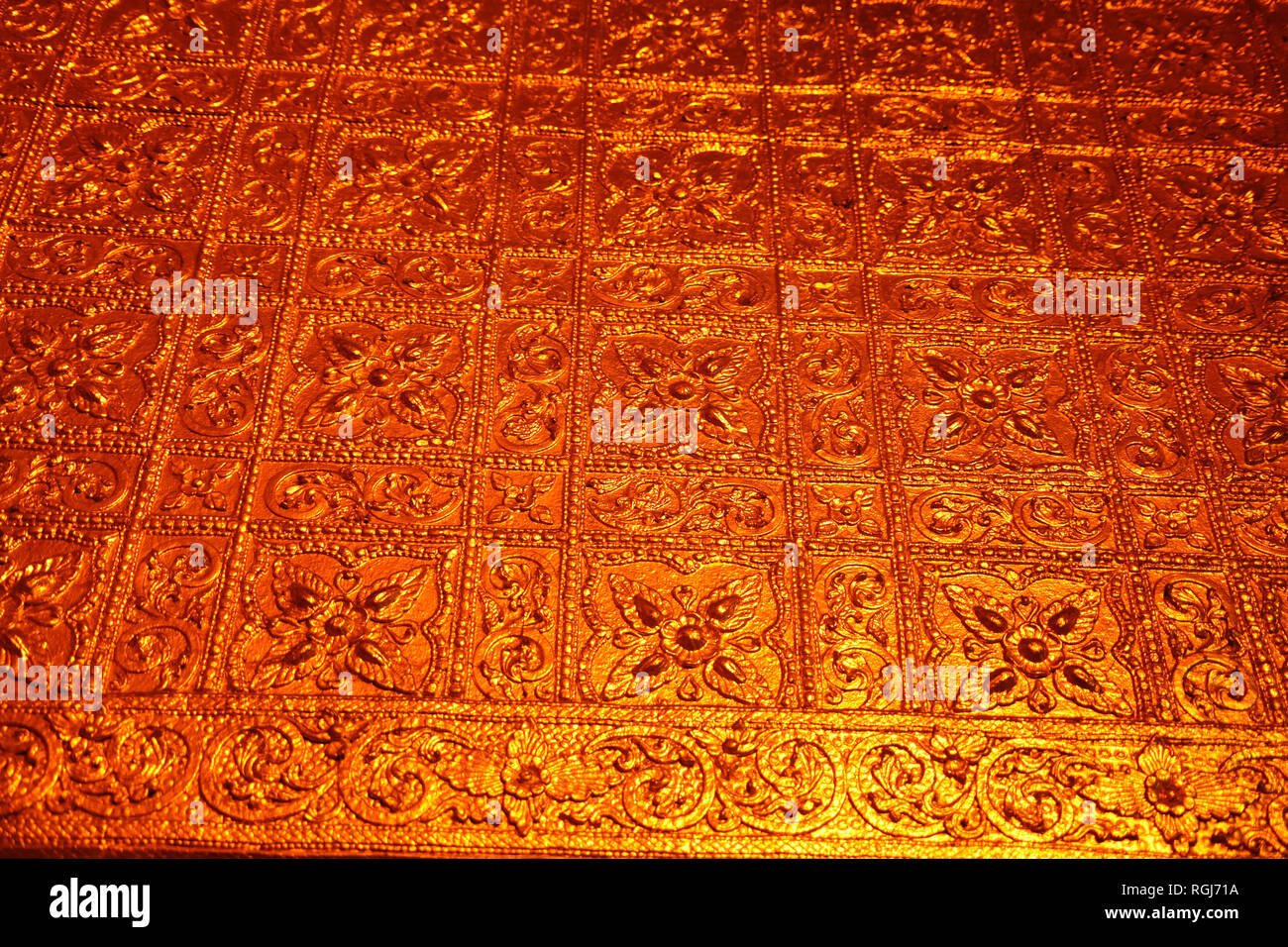 Cerca de una pared de oro diseñado con flores en el interior de la pagoda Botataung Budista, Yangon, Myanmar. Foto de stock