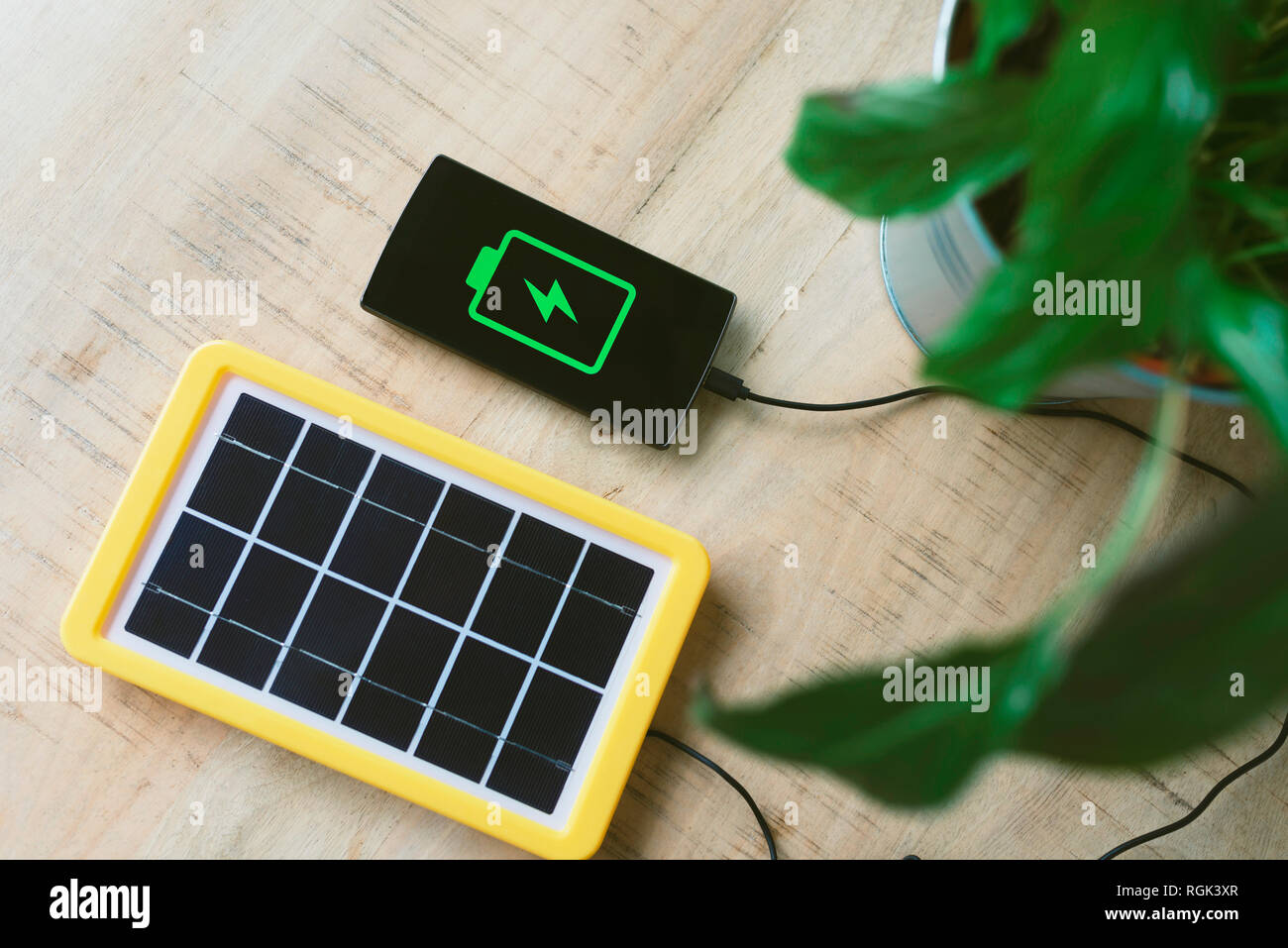 La tecnología de la energía renovable, el panel solar carga la batería del teléfono móvil. Foto de stock