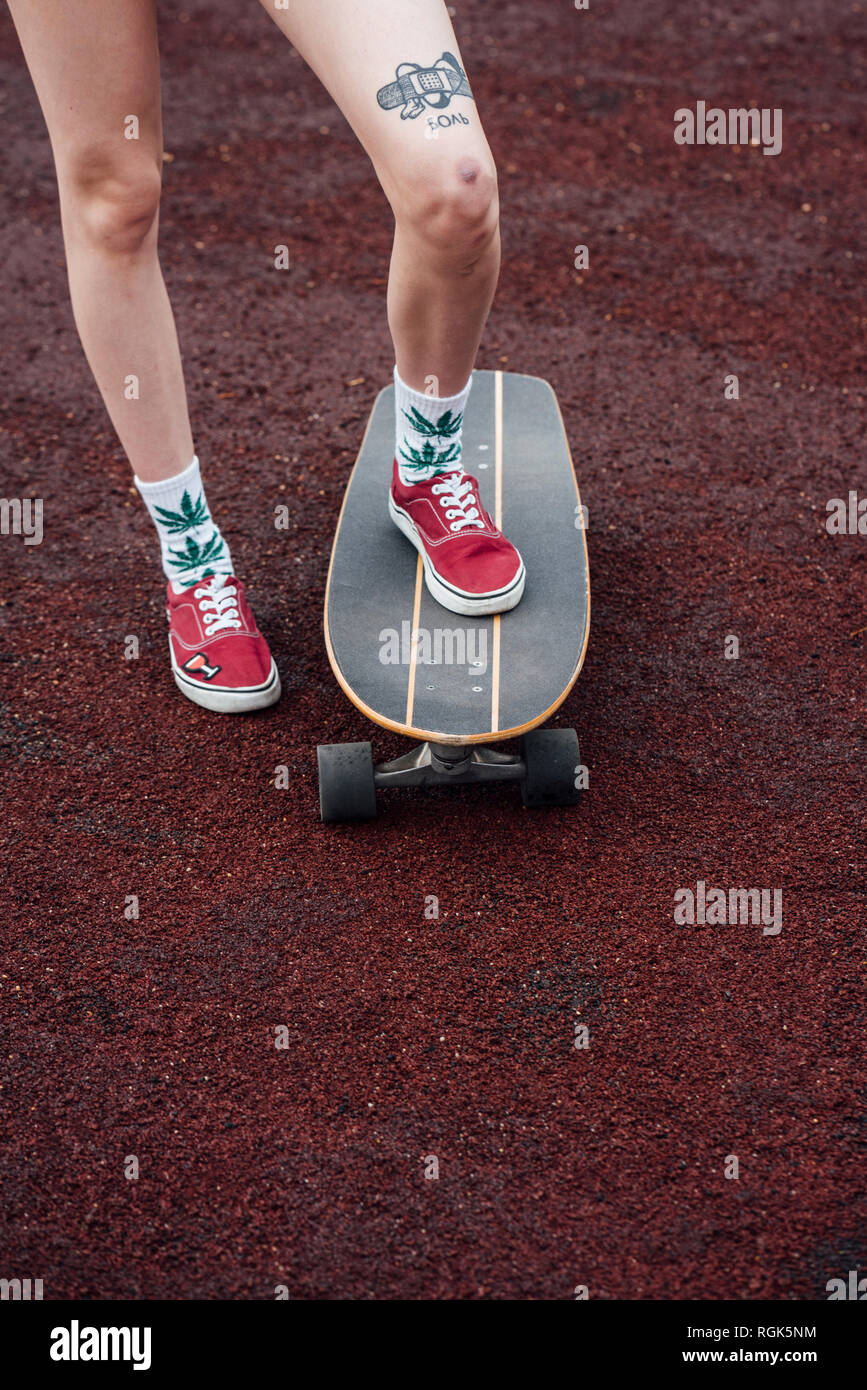 Las piernas de una mujer en calcetines y zapatillas pie sobre skateboard Fotografía de stock - Alamy