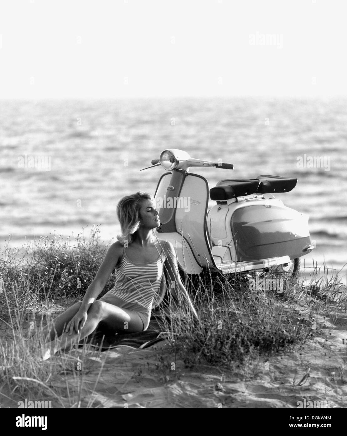 Chica en la playa, lambretta, Italia 1965 Foto de stock
