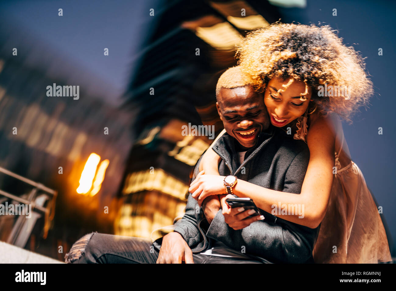 Pareja joven busca en el smartphone de noche Foto de stock