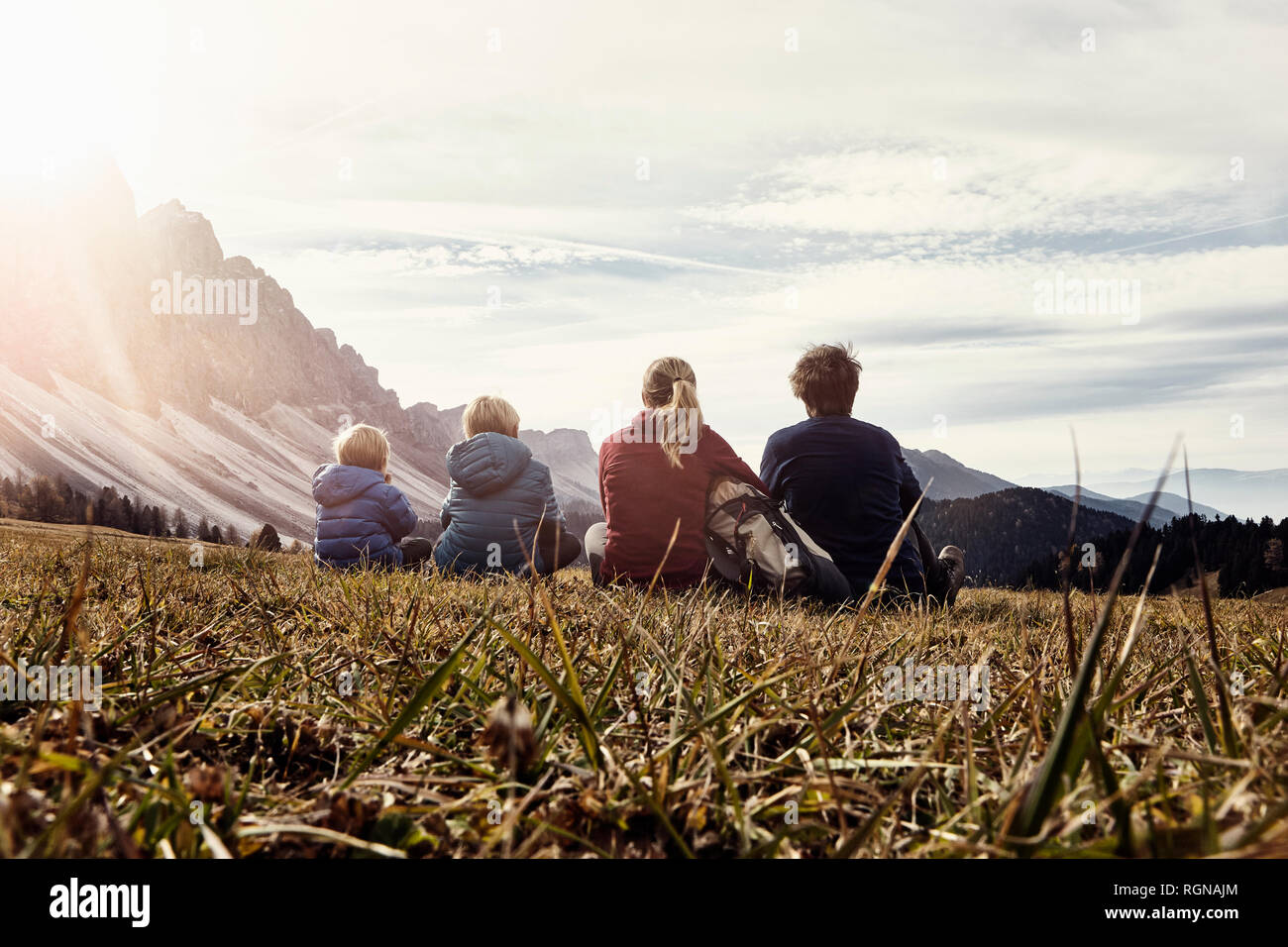 Italia, el Tirol del Sur, Geissler senderismo en grupo, en familia, sentados en pradera Foto de stock