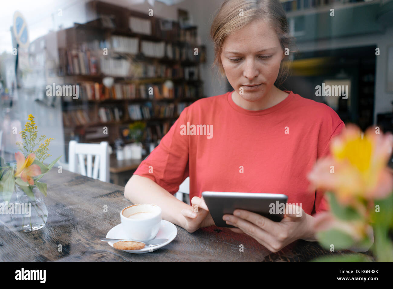 Mujer joven con tablet en la ventana en un café Foto de stock