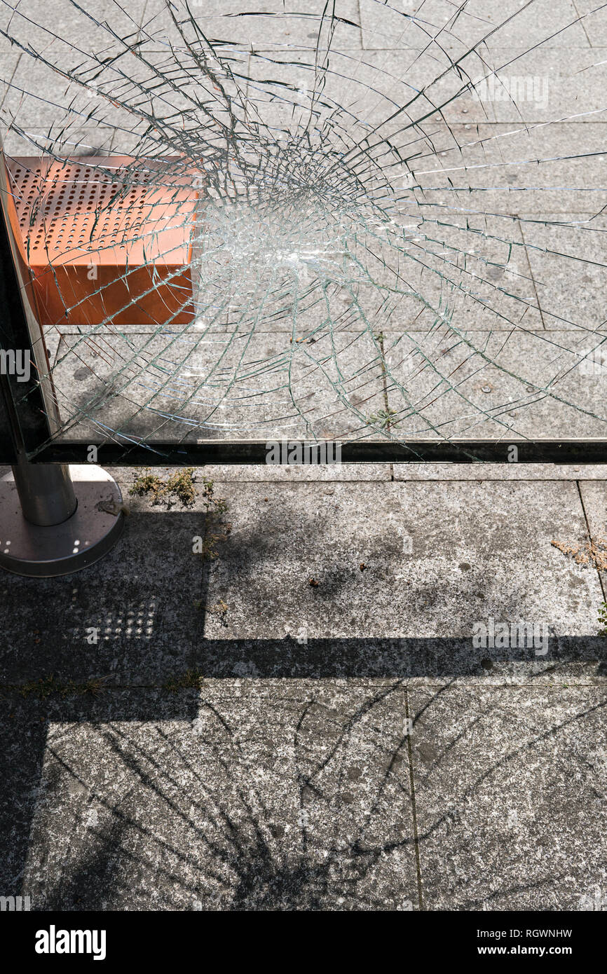 Concepto de vandalismo. Vidrio dañado en la parada del autobús refugio. Los problemas sociales Foto de stock