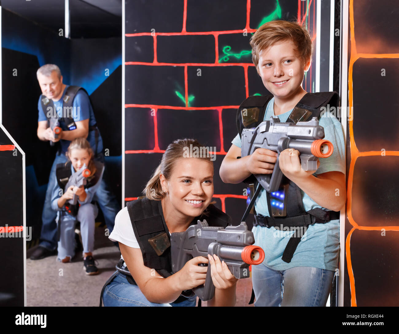 Moderna y joven madre hijo adolescente con pistolas láser jugar laser tag  en el oscuro laberinto Fotografía de stock - Alamy